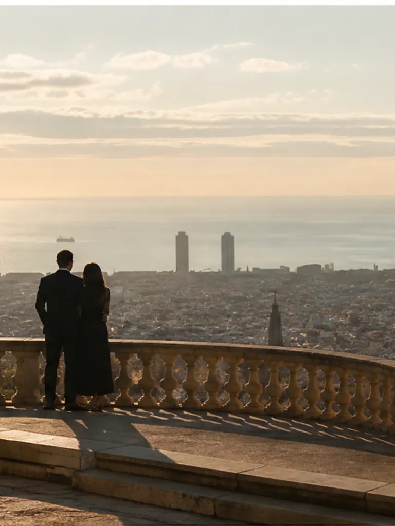 Miramar overlook over Barcelona at soft golden hour, discreet photographer distance for a luxury proposal