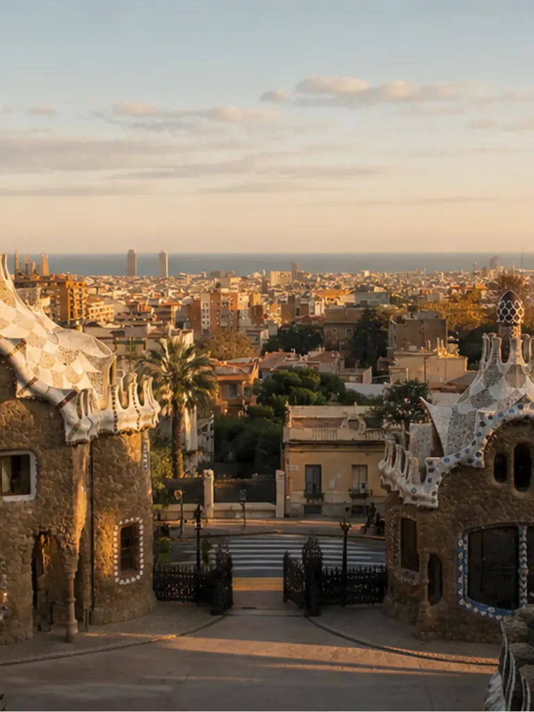 Park Güell entrance pavilions at soft golden hour, quiet-luxury Spain proposal planning mood